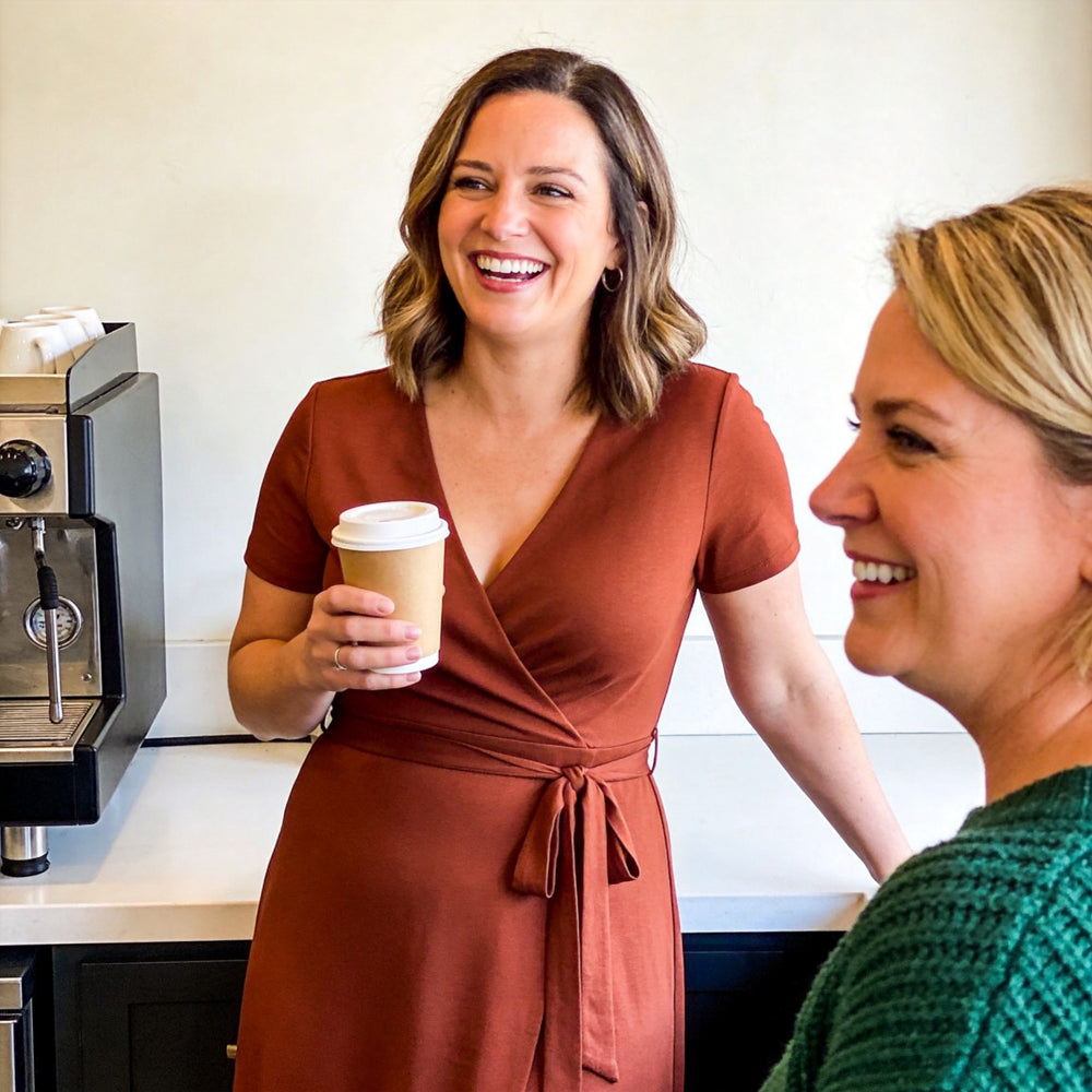 Mom laughing with a coffee in a wrap dress